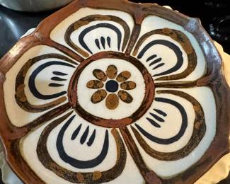 A Ken Edwards Tonala pottery plate with a hand-painted lotus flower design.