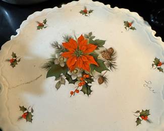 Vintage ceramic decorative plate with poinsettia and holly motif.