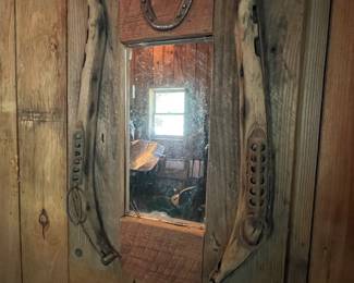 Handmade rustic mirror with horseshoe and reclaimed wood frame.