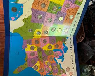 A U.S. State Quarters collector's map with circulating coins.