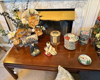 Asian-inspired decorative assortment featuring patterned tins, figurines, and complementary pieces with classic motifs. Versatile grouping ideal for display, layering, or decorative use.