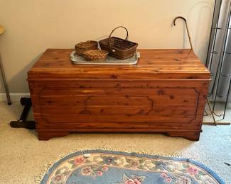 Cedar chest with warm wood tone and classic paneled front. Solid storage piece with timeless style, ideal for blankets, linens, or use as a coffee table.