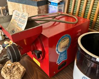 Commercial peanut butter grinder machine with red metal housing and feed hopper. Great for small-batch production, homesteaders, farm market use, or eye-catching display.