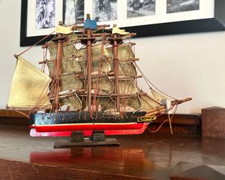 Decorative sailing ship model with detailed rigging and fabric sails. Eye-catching display piece with classic nautical character.