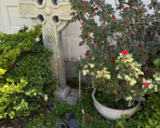 Large cement garden cross and a potted rose bush 