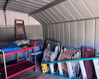 Ladders, cart, vintage lawn chairs in building