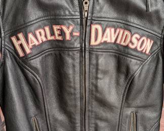 Women's Harley-Davidson "Genuine Motor Cycles" Leather Jacket (likely part of or related to the Pink Label collection). This is a sought-after style for estate sales because the pink embroidery appeals to a specific niche of female riders.