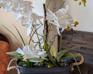 farmhouse-style artificial white orchid arrangement featuring faux moth orchids in a rustic dark container with rope handles. 