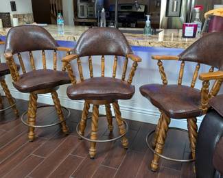 vintage Captain's Chair style swivel bar stools, likely dating from the 1970s or 1980s. They feature a distinct "Old World" or rustic aesthetic that was popular in home bar setups during that era.