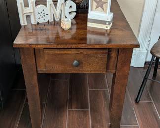 Intercon Furniture Kona Raisin End Table, which features a rich raisin finish and a storage drawer with brushed metal hardware. 