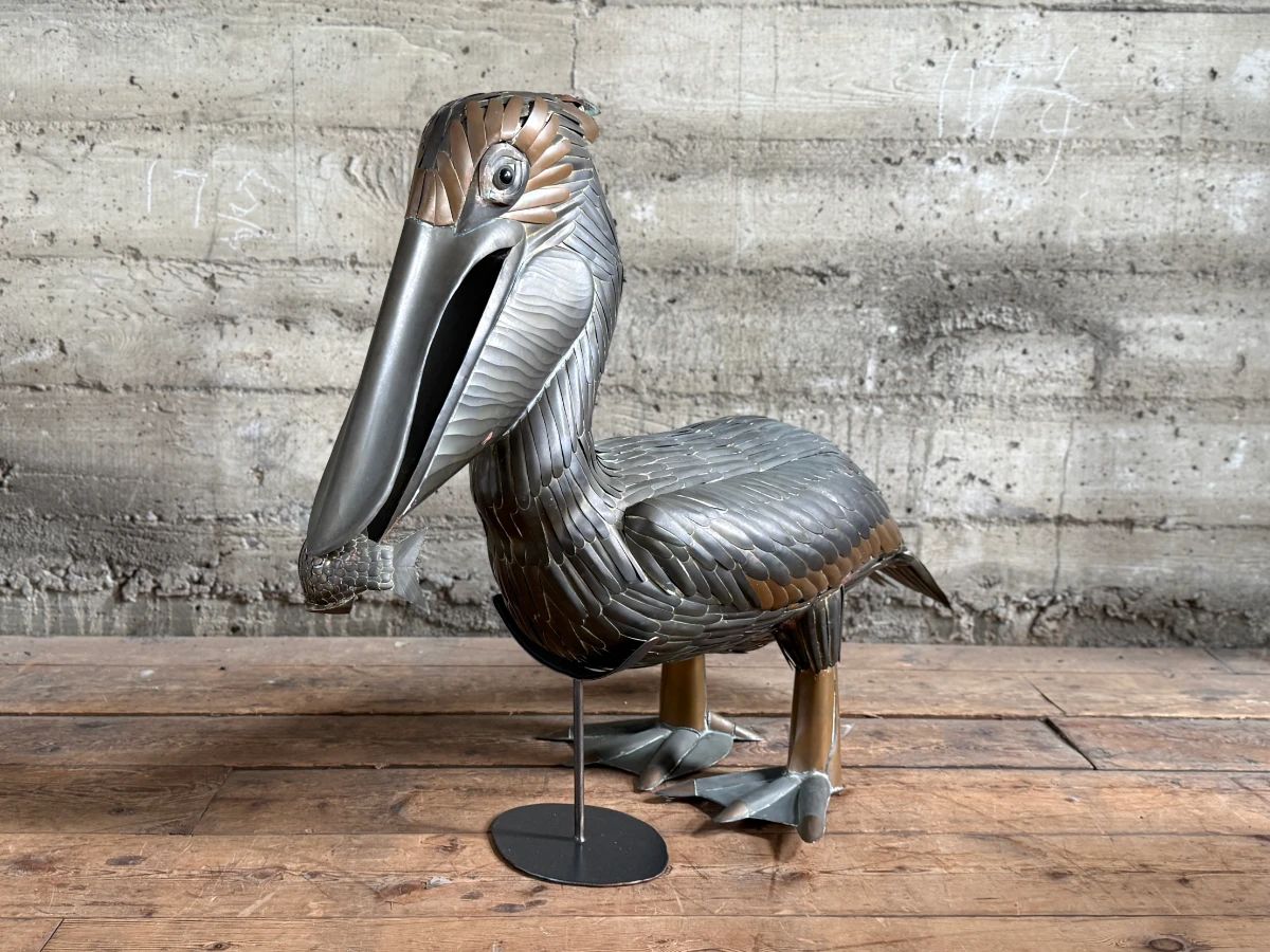 This lot features an original copper and brass sculpture of a pelican by listed artist, Sergio Bustamante. Limited to only 100 made, this sculpture was purchased from the gallery with original purchase receipts and an appraisal from Karen Asher of Karen Asher Galleries. Minor wear throughout as shown in photos and measures, 28” H x 36” W x 16” D.