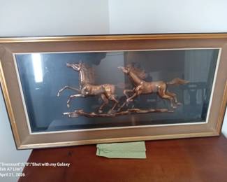 Three Dimensional look with brass horses behind glassed frame.