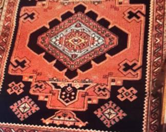 Machine made Kazak style rug.  Wool pile from India 5’6”x7’6”, rust & navy blue