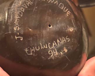 item is a piece of Chulucanas pottery from Peru, featuring a signature and date on the bottom. Artist: The piece is signed "J. Sandoval Adanaque," likely referring to a member of the Sandoval family known for this ceramic style. Origin: Chulucanas pottery is a traditional craft from the Piura region of Peru, known for its distinctive black-and-white patterns and clay techniques. Date: It is dated 1994.