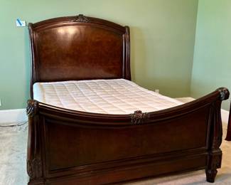 Carved wood sleigh bed with rolled headboard and footboard