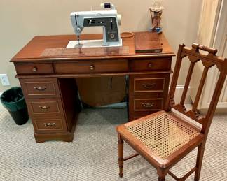 Vintage sewing setup – Singer machine in wooden desk with cane chair