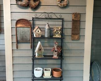 Metal plant stand with birdhouses, planters, and garden décor.