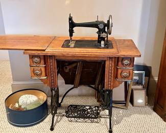 Antique treadle sewing machine in oak cabinet with cast iron base 