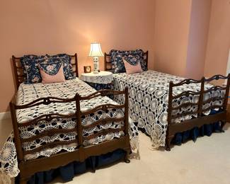 Pair of vintage twin beds with carved wood frames and decorative headboard/footboard