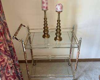 Brass and glass tea cart, brass candlesticks