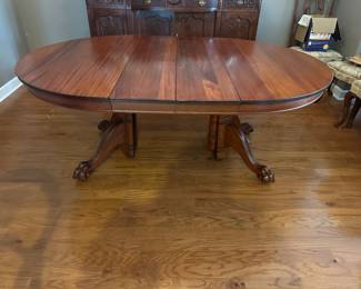 Mahogany dining table with two of the four extensions and the split pedestal shown. 