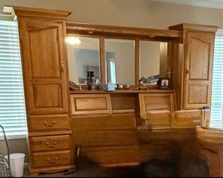 Beautiful, solid wood bedroom set available! This set features a large bed with an attached headboard and built-in mirror, along with matching pieces including a dresser, chest, and armoire. Tons of storage throughout with spacious drawers and cabinets.  This is a complete, well-made set with a classic look that would be perfect for a primary bedroom. Everything is in good condition and priced to sell!