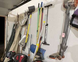 high-reach tools, including metal and plastic snow shovels, garden rakes, and brooms, as well as a Bell Floornado floor pump for tires.