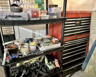 This collection focuses on precision work and shop organization, featuring a Dremel rotary tool in its original hard case and an array of professional-grade adhesives. The inventory includes heavy-duty Gorilla and Scotch brands of tape, various fastener organizers filled with specialized screws and anchors, and high-capacity ratchet tie-down straps for hauling. It represents a well-stocked supply of the essential "consumables" and small power tools required for home maintenance.