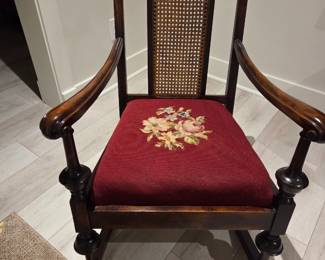 Decorative, traditional armchair, combines carved wood, cane work, and embroidered upholstery for a classic aesthetic.