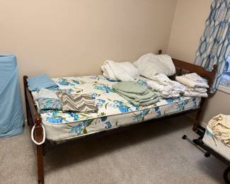 twin bed with linens & fabric pieces