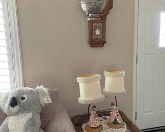 In addition to the almost hidden Regulator clock, and the koala stuffed plushie, the side table holds two small figurine lamps.  Also, the match to the hurricane lamp hangs here.