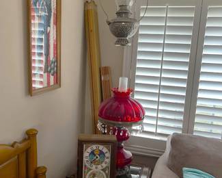 On the table next to the sofa is the matching red table lamp to the hanging lamp in the previous picture.  There is also a hanging oil lamp (again, hurricane-style).  I don't see any wires leading to it, so it could be purely decorative, oil-burning, or run on batteries.  The clock is from Burpee Seeds.