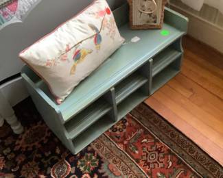 A handmade bench in blue or can be hung on the wall. Has shelves in it.