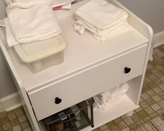 White cabinet in master bath with drawer and bottom shelf.