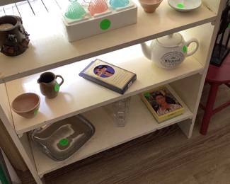 Book shelf in den with pottery and other items.