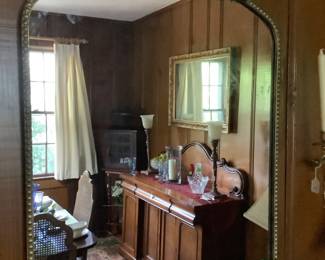Gold mirror with rosettes in dining room.