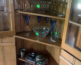 Corner built in cabinet loaded with several sets of crystal glasses, pewter, crystal bowls.