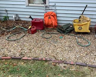 Gas cans, seats, back packs, water hose outside.