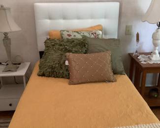 The twin bed in other bedroom with white tufted headboard and black metal frame.  No box springs required.  Has a white end table and oak mission end table.