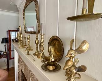 Mantel full of brass objects.