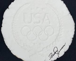 Lot 71	Bruce Jenner Signed USA Olympic Carved Plaster Or Marble Composite Medallion, 1976 Montreal Olympics Decathlon Gold Medalist, Hand Signed In Black Ink