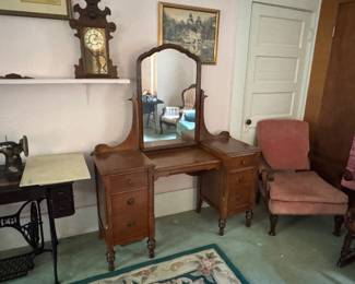 vintage wooden vanity with a large, arched mirror.