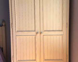 Ivory clothing storage armoire with drawer