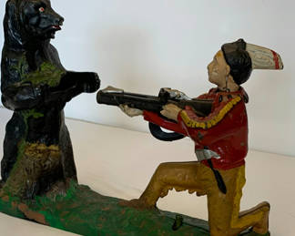 Lot 9: Antique Painted Cast Iron Piggy Bank of Native American hunting a Bear