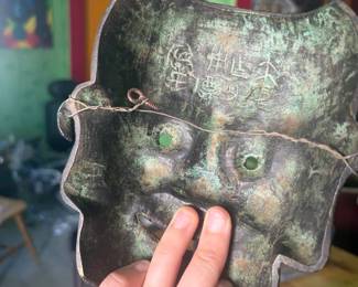  A remarkable pair of antique iron masks, believed to be 19th century, brought to the United States by a diplomat with extensive ties to East Asia. One is a fully three-dimensional demon/oni face with jade-green glass eyes and detailed etched features. The second is a flat iron mask with a fierce expression, jade-green glass eyes, and Chinese characters inscribed on the reverse, with a wire hanger. Both show beautiful age patina. Exceptional collector's pieces with genuine provenance.