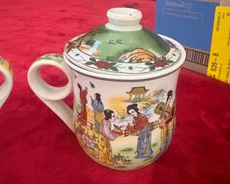 Set of 2 Two beautifully decorated lidded Chinese porcelain tea mugs. One features a yellow ground with blue and grey dragon motif; the second depicts court ladies in a garden scene with a green-topped lid. Both in good condition. A lovely pair from a diplomat's personal collection.