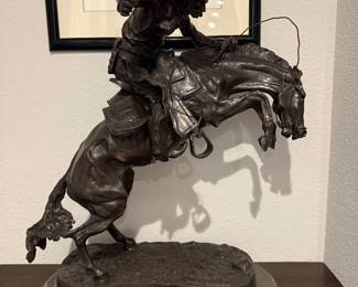 Reproduction of Frederick Remington’s “The Bronco Buster.” Weight 54 lbs, solid bronze casting, missing small revolver.