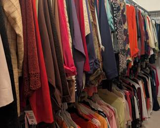A closet full of ladies clothes mostly dress clothes 