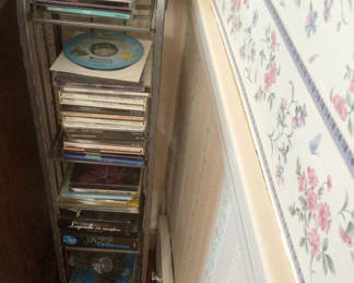 Lot 4: CD rack with stacked music CDs