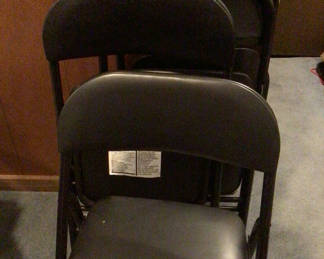 Lot 165: Stacked black folding chairs and card table